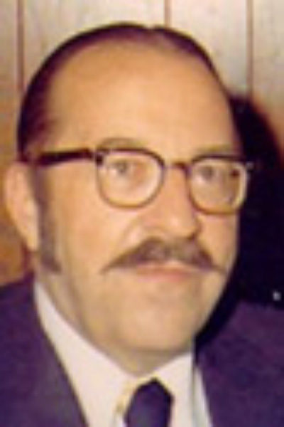 candid photo of Wilson Smead, a previous HRCCU board president with brown thick-rimmed glasses and a mustache