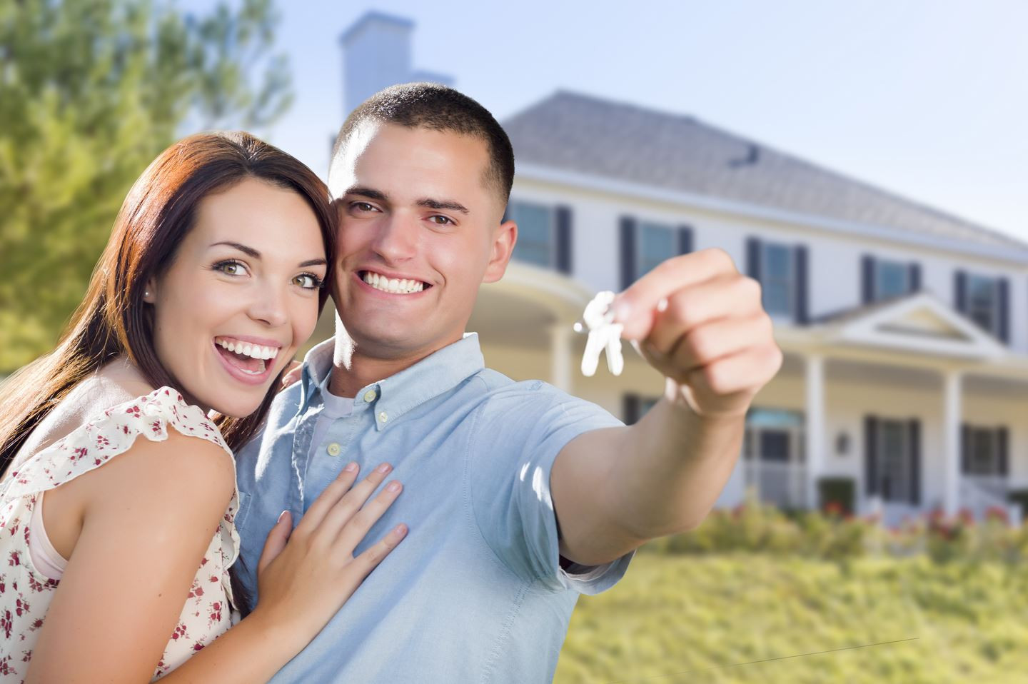 first-time homebuyers standing in front of new home after following helpful tips during their search and mortgage process