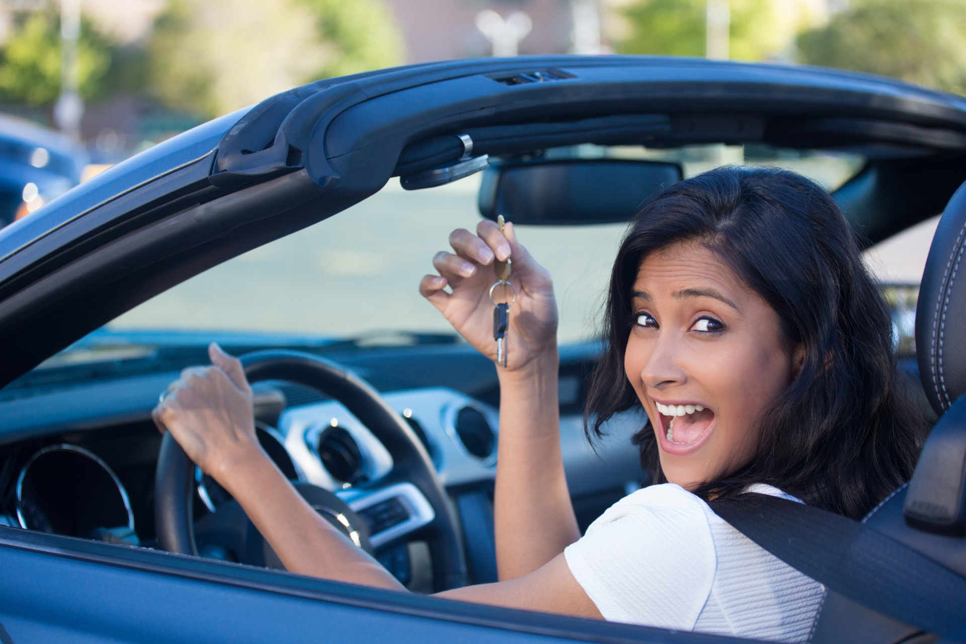 young female in a new car after deciding whether leasing or buying a new vehicle is the right option for her