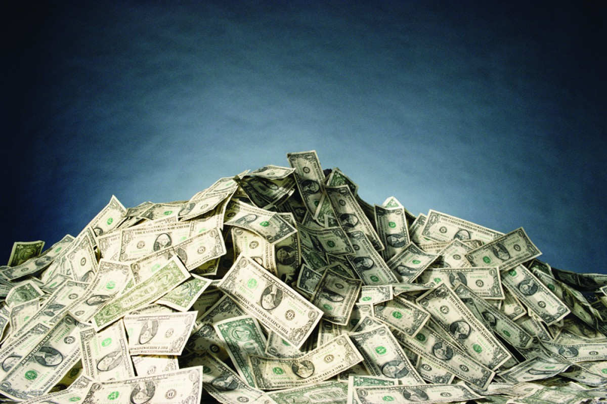 creative image featuring a pile of cash money representing a lump sum or installment payment when getting a loan