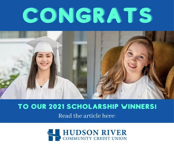 woman with brown hair wearing a white graduation cap and gown next to a woman with red hair sitting in a brown armchair