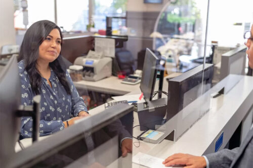 Cheerful bank teller assisting a customer