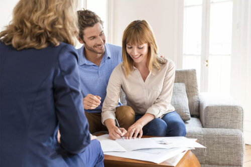 Young couple signing a contract for house investment.
