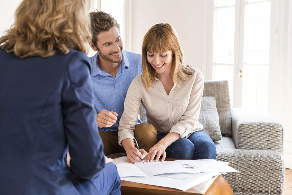 Young couple signing a contract for house investment.