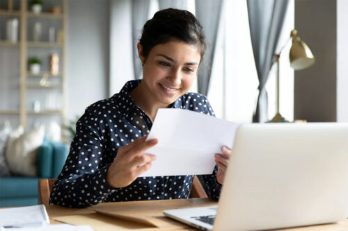 teenage girl smiles are bank statement with laptop