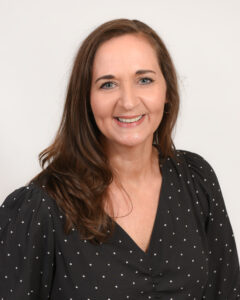 photo of Chief Retail Officer Paula Sheely wearing a black shirt in the center of a blank white background
