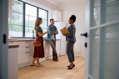 A couple speaking with a real estate agent looking at new home options with mortgage assistance.